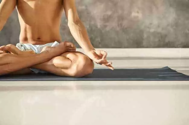 hot-young-male-with-muscular-torso-arms-sitting-padmasana-making-mudra-gesture-unrecognizable-man-practicing-yoga-mat-lotus-pose-meditation-concentration-wellness_343059-3119